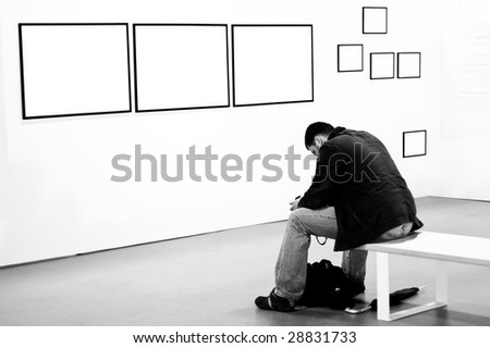 A man thinking and pondering at a photographic exhibition's gallery