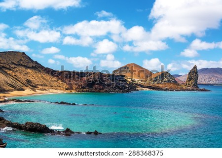 View of an underwater crater in the foreground with Pinnacle Rock in the background on Bartolome Island in the Galapagos Islands Royalty-Free Stock Photo #288368375