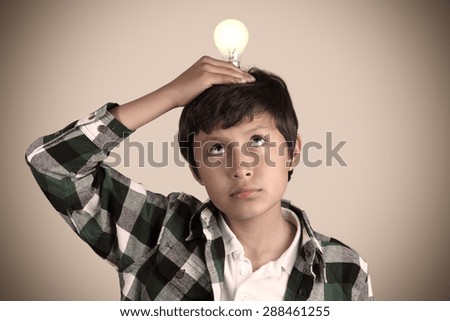Portrait of young boy with light bulb with vintage look and vignetting