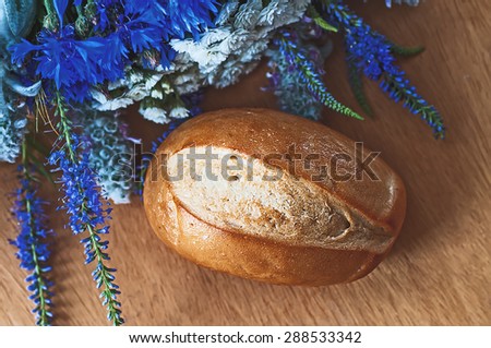 Rustic bread and rural flowers  on  wood table. vintage picture