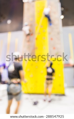 blurred image of people climbing wall , blur background with bokeh .