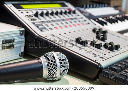 dynamic microphone, digital studio mixer & keyboard synthesizer, focus on mic for music recording, radio / tv broadcasting background