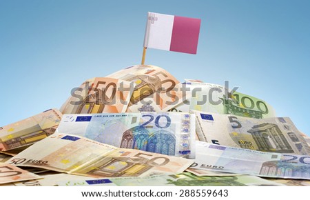 The national flag of Malta sticking in a pile of mixed european banknotes.(series)