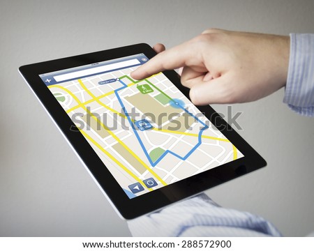 route planner concept: hands with touchscreen tablet with gps navigation app on the screen. Screen graphics are made up. 