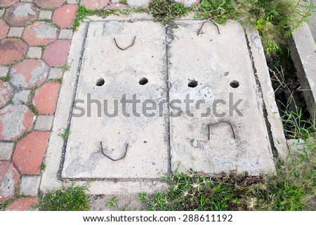 Smiling and frowning face (happy and mad), emotions of concrete manhole on footpath