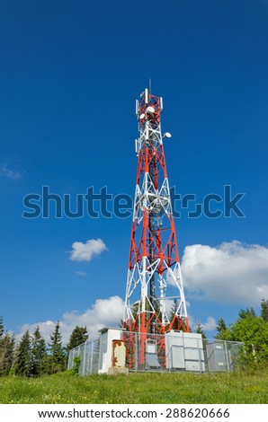 Telecommunications tower with blue sky and clouds