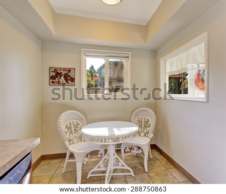 Extra dinning area with white table and chairs, and two windows.