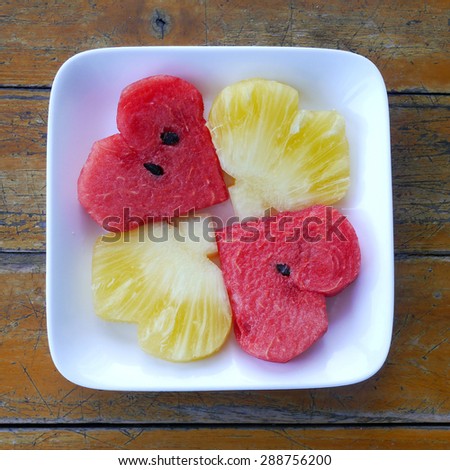 Heart shaped Pineapple and watermelon on wooden background