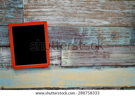 Red wooden frame hanging on a wooden board.