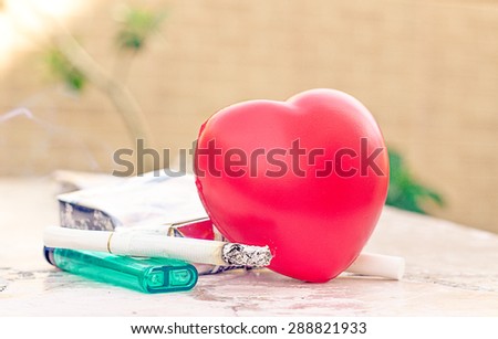 heart and care concept: cigarette and heart shape on the table.