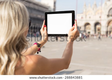 Tourist taking photo with tablet computer with empty white screen