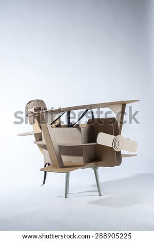 Photo of  cardboard plane and aviator hat on white background. 