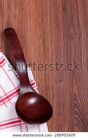 red wooden spoon on a napkin in a cage on wooden background