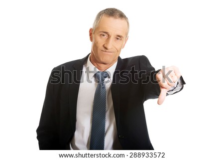 Portrait of businessman showing thumb down sign.