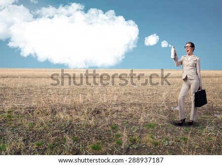 Young businesswoman with suitcase using spray balloon