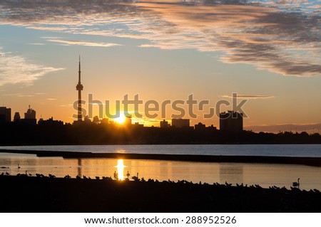 Toronto skyline at sunset with reflections on Lake Ontario