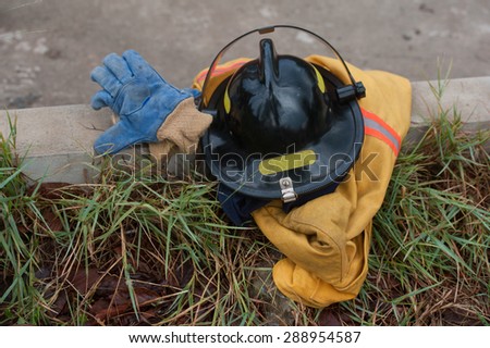 Heavy Duty Protective Fire Fighting Cloth, Gloves, Helmet, Jacket, Pants, on Green Grass Background