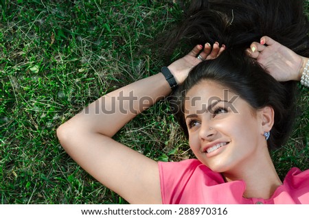 ortrait of a beautiful girl lying on the grass