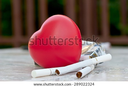 Heart and care concept: cigarette and heart shape on the table.