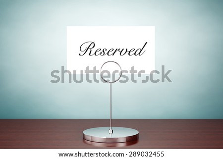 Old Style Photo. Note Paper Card Holder with Reserved Sign on the table