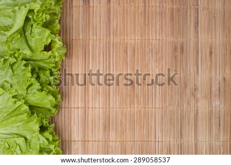 lettuce leaves laid on both sides on a bamboo table cloth