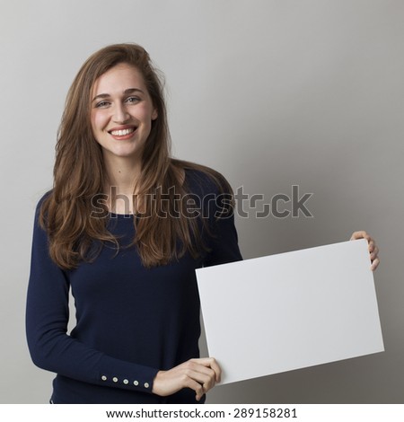 thrilled young girl holding a white communication board with positive news on