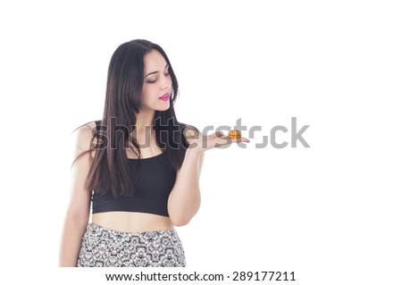 Beautiful woman holding an orange macaroon against a white background