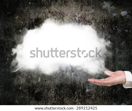 Male hand showing white cloud with dark concrete wall background