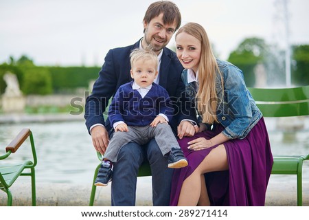 Happy family of three in the beautiful Tuileries garden in Paris