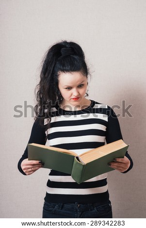 Woman reading a book. On a gray background.