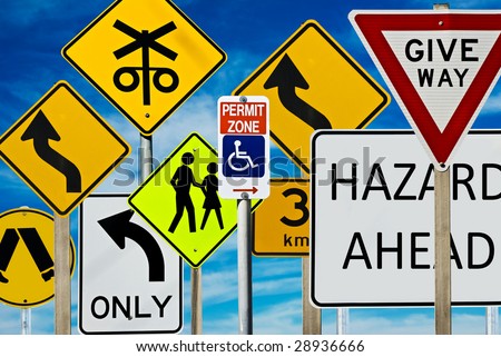 Multiple road signs against a blue cloudy sky. Signs include: giveway, hazard, pedestrian crossing, left turn only, railway crossing and more.