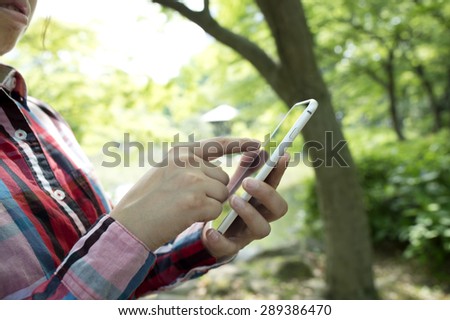 Cheerful smiling woman texting with her mobile phone