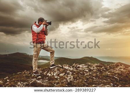 Photographer is taking a picture of  landscape in mountains