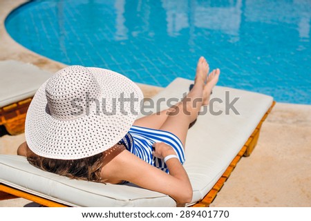 woman lying on a lounger by the pool at the hotel.