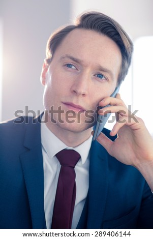 Serious businessman having a phone call in his office