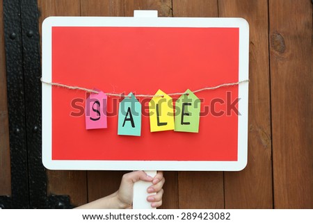 Sale sign on wooden fence background