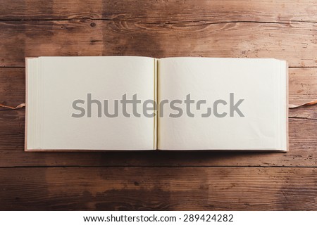 Photoalbum with an empty space for photos. Studio shot on wooden background. Royalty-Free Stock Photo #289424282