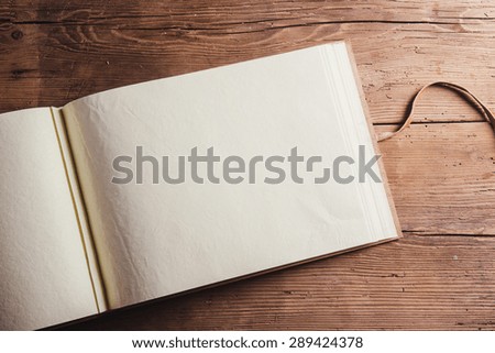 Photoalbum with an empty space for photos. Studio shot on wooden background. Royalty-Free Stock Photo #289424378