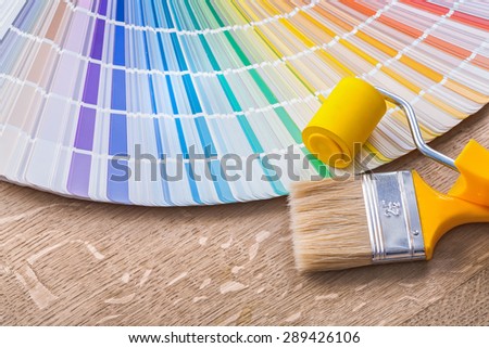 paint brush roller and color palette on wood board.
