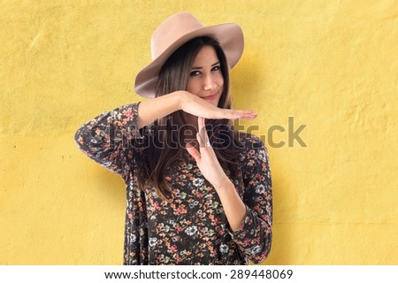 Woman making time out gesture  over textured background 