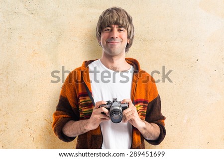 Blonde man holding a camera