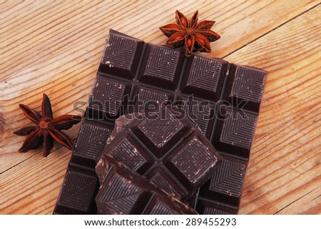 split bar of dark chocolate on wooden table