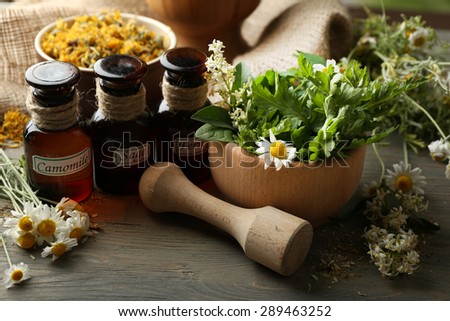 Herbs, berries and flowers with mortar, on wooden table background Royalty-Free Stock Photo #289463252
