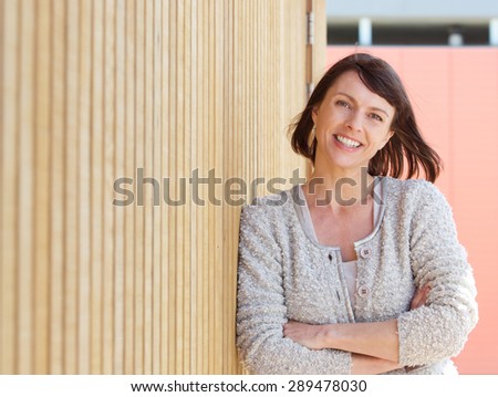 Close up portrait of a natural older woman smiling with arms crossed