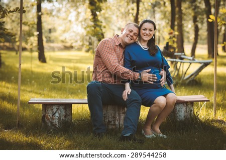 Happy family. Pregnant mother with her husband at the park.