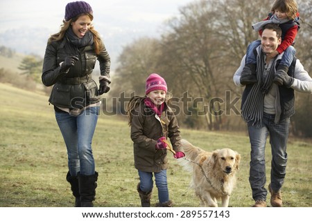Family and dog on country walk in winter Royalty-Free Stock Photo #289557143