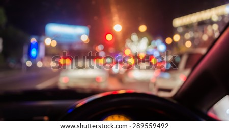 blur image of inside cars with bokeh lights from traffic jam on night time.