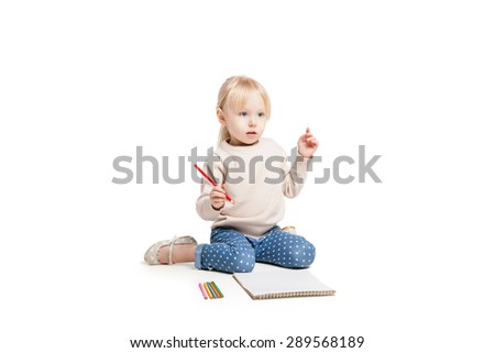 Little cute girl sitting on floor and drawing with colourful pencils