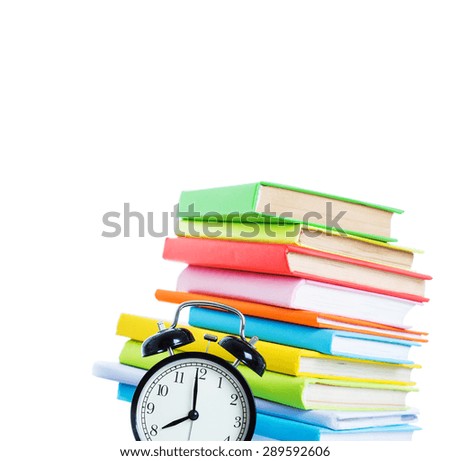 Alarm clock and stack of books on a white background