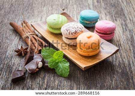 macarons with chocolate on wooden background, rustic style